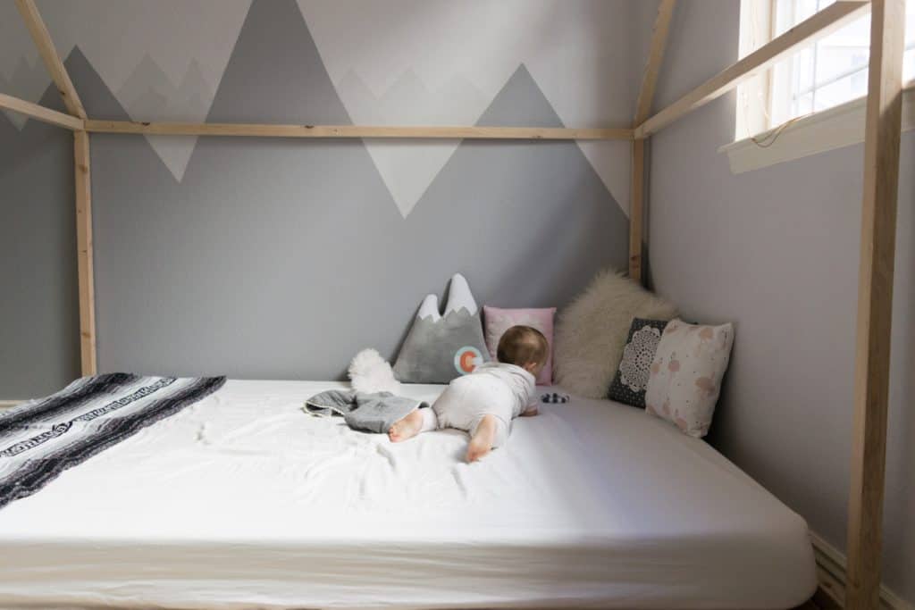 DIY Mountain Nursery with Wall Mural 4 Montessori style floor bed with wooden house frame against DIY mountain wall mural