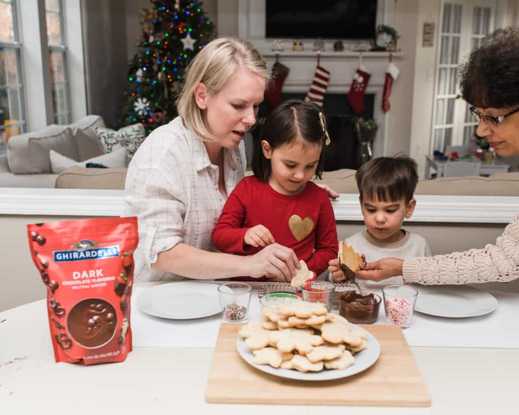 kids decorating cookies with grandma and mom